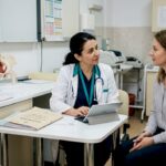 Medic și pacient discută în cabinet, analizând împreună rezultatele și planul de tratament.