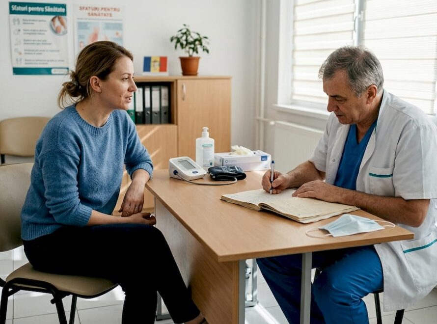 O femeie stă de vorbă cu medicul într-un cabinet medical.