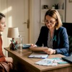 Medicul poartă o discuție relaxată cu o pacientă într-un cabinet primitor, unde atmosfera este caldă și liniștitoare.