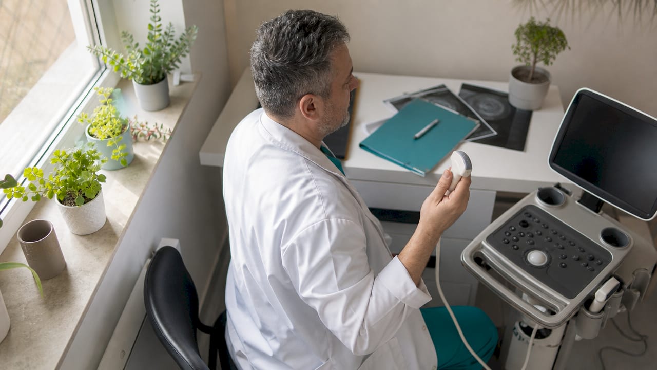 Tehnicianul medical realizează investigații cu ajutorul ecografului.
