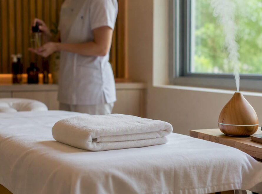 Masă de masaj amenajată într-un spațiu de clinică, cu o atmosferă liniștită și relaxantă.